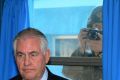 A North Korean soldier, right, tries to take a photograph through a window while US Secretary of State Rex Tillerson ...