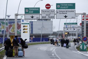 Travellers walk on the highway to the Orly airport, south of Paris, Saturday, March, 18, 2017. A man was shot to death Saturday after trying to seize the weapon of a soldier guarding Paris' Orly Airport