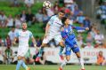 Flying high: Tim Cahill of the City heads the ball over John Koutroutmbis of the Jets for a goal.