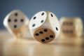 Rolling three dice on a wooden desk die dice?