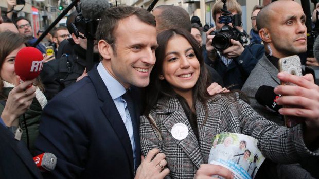 Independent centrist presidential candidate Emmanuel Macron poses for a selfie after visiting a police station in Paris.