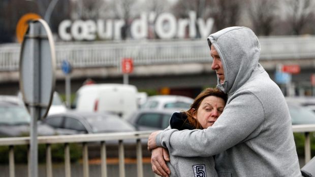 Travellers hug outside Orly airport after one of its two terminals was evacuated on Saturday.