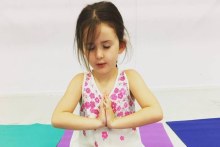 Child in peaceful yoga pose (Supplied: Jade Malinovski)