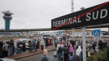 Passengers wait on tarmac