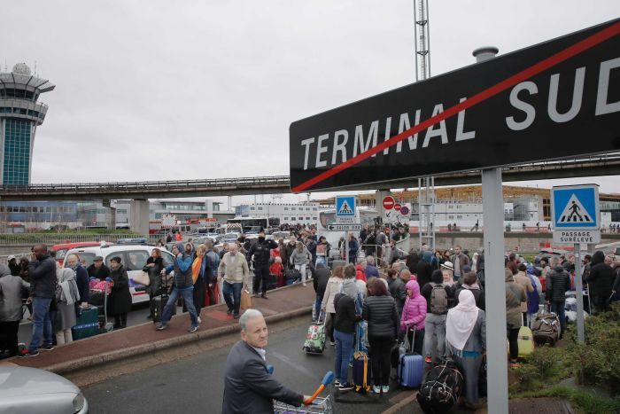 Passengers wait on tarmac