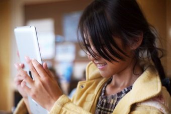 A young girl uses an iPad.