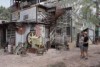 people outside a demountable home with signs all over it