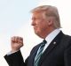 President Donald Trump with his wife first lady Melania Trump and their son Barron, pumps his fist as they disembark ...