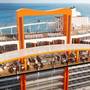 The Magic Carpet spans 16 storeys on the ship. This picture also shows the raised hot-tubs in the pool area and the running track.