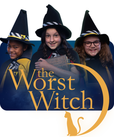 Three young girls are dressed in black cloaks and wearing witches hats (Enid, Mildred and Maud).