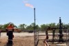 The Amungee shale gas wellhead (right foreground) and gas being flare