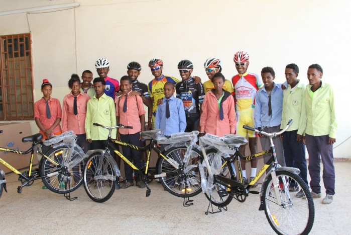 Students posing with professional cyclists
