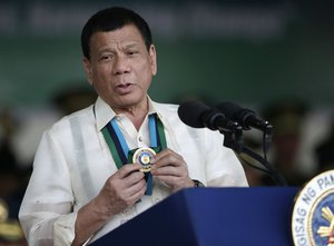 Philippine President Rodrigo Duterte shows a medal during his speech to troops during the 81st anniversary of the Armed Forces of the Philippines at Camp Aguinaldo military headquarters in Quezon city, north of Manila, Philippines on Wednesday, Dec. 21, 2016.