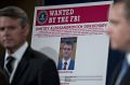 A wanted poster for Dmitry Aleksandrovich Dokuchaev sits on display during news conference at the Department of Justice ...