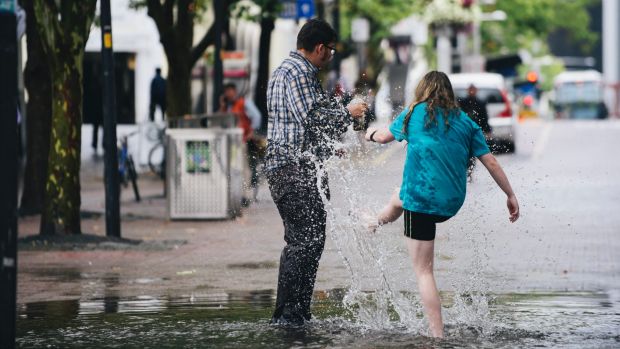 Friends Jayden Goodrem, 18, of Paige, and Ashleigh Peet, 19, of Kambah enjoy a puddle in Garema Place.