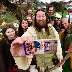 Saint Patrick, played by actor Marty Burns takes a selfie along with members of the Magnus Vikings Association before they part in the cross community Saint Patrick's Day parade on March 17, 2017 in Downpatrick, Northern Ireland. (Photo by Charles McQuillan/Getty Images)