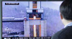 A man in Seoul watches a TV news programme showing an image reportedly of a North Korean ground test of a new type of high-thrust rocket engine (Ahn Young-joon/AP)