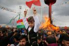 People gather around a bonfire after Turkish authorities permitted the Newroz celebration, in Diyarbakir, Turkey, ...