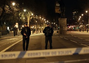 Two policemen stand guard at a cordoned off area on the way to the Houses of Parliament in central London, Wednesday, March 22, 2017.