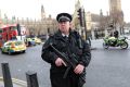 Armed officers attend to the scene outside Westminster Bridge.