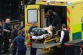 An attacker is treated by emergency services outside the Houses of Parliament in London, on Wednesday.