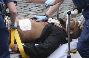 An attacker is treated by emergency services outside the Houses of Parliament London, Wednesday, March 22, 2017.