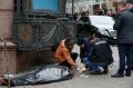 Forensic experts and police officers examine the scene following the killing of Denis Voronenkov in Kiev, Ukraine.