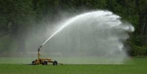 In this Aug. 28, 2003 file photograph, a sprinkler sprays water onto a hay field near Hoxie, Kan.