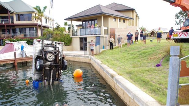 The crane winching the ute from the water.