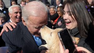 Former Vice President Joe Biden gets a kiss from a dog as he greets the crowd on Capitol Hill in Washington, Wednesday, ...