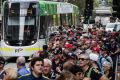 Big crowds wait in line to catch a tram to the Grand Prix on Friday.