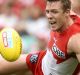 Out-contested: Luke Parker of the Swans falls as he competes for the ball with Matthew Broadbent.