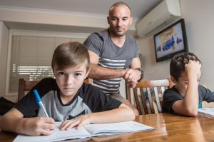 SYDNEY, AUSTRALIA - MARCH 17: Painter, Craig Zammit helps his sons, Thomas and Mason with their homework. He and his ...