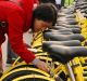 A Beijing commuter unlocks her share bike.