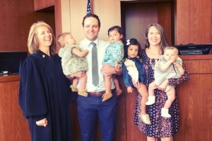 The new parents of four and the judge who made the adoptions official.