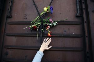 A woman places flowers on a train wagon at the old train station in Thessaloniki, Greece on Sunday, March 19, 2017. ...