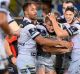 Coen Hess of the Cowboys is congratulated by team mates after scoring a try.