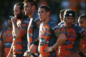 Overrun: Tigers players look dejected after blowing a 14-0 lead at home to the Storm.