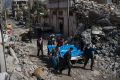 Residents carry the bodies of several people killed during fights between Iraq security forces and Islamic State on the ...