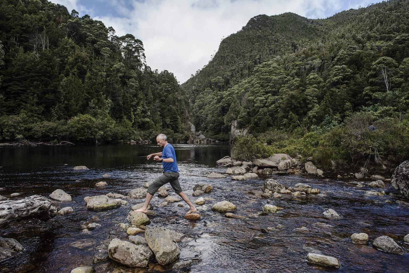 Geoff Law tiptoes across rocks at Rafter&#39;s Basin, where river parties – after almost a week in the wilderness – often stop to bathe.