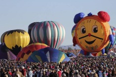 Hot air balloons, one of them shaped like a clock, are prepared before taking flight during the 42nd annual Albuquerque ...