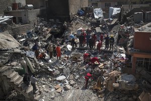 Civil protection rescue team work on the debris of a destroyed house to recover the body of people killed during fights between Iraq security forces and Islamic State on the western side of Mosul, Iraq, Friday, March 24, 2017.