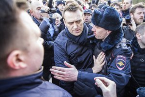 In this photo provided by Evgeny Feldman, Alexei Navalny is detained by police in downtown Moscow, Russia, Sunday, March 26, 2017.