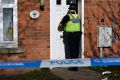A policeman enters a property in Birmingham on Friday.  