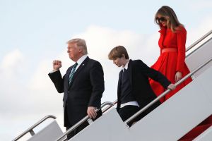 President Donald Trump with his wife first lady Melania Trump and their son Barron, pumps his fist as they disembark ...