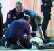 Police and ambulance officers treat the injured man at Preston station.