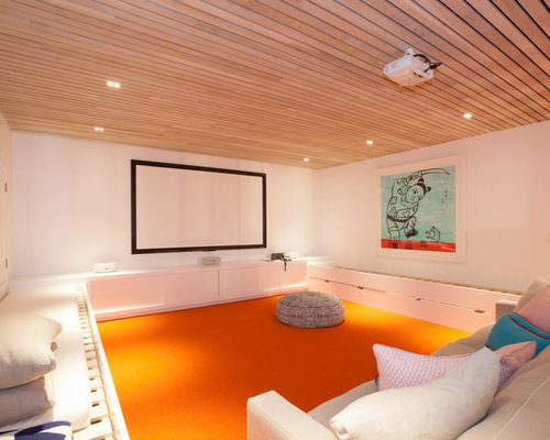 This is an example of a mid-sized contemporary enclosed home theatre in Sydney with white walls, carpet and a projector screen.