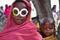 A young Somali girl displaced by the drought wears a pair of mock spectacles cut out from a cardboard box of antibiotics ...