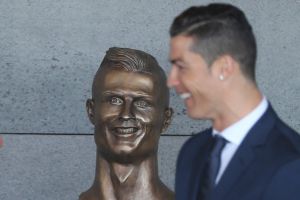 Football superstar Cristiano Ronaldo stands next to the dubious statue.