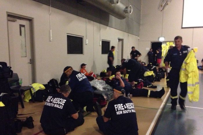 Emergency staff sit in the evacuation centre in a town hall in Proserpine